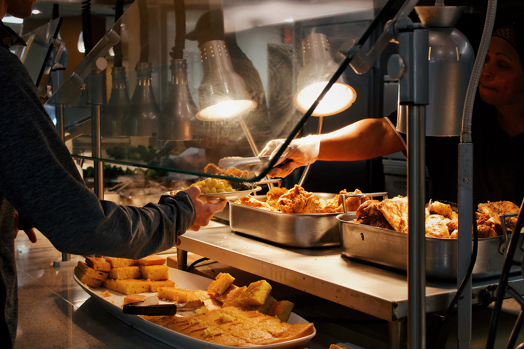 Someone serving food in a cafeteria